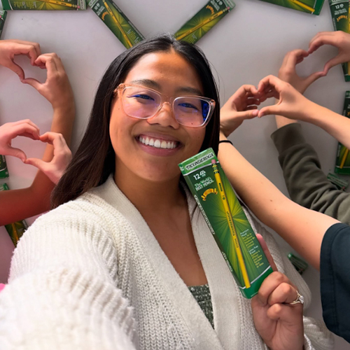 Teacher holding up a box of pencils